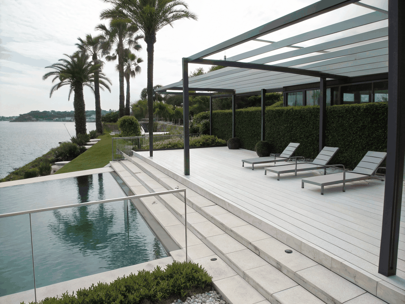 Modern grey composite decking built around swimming pool terrace