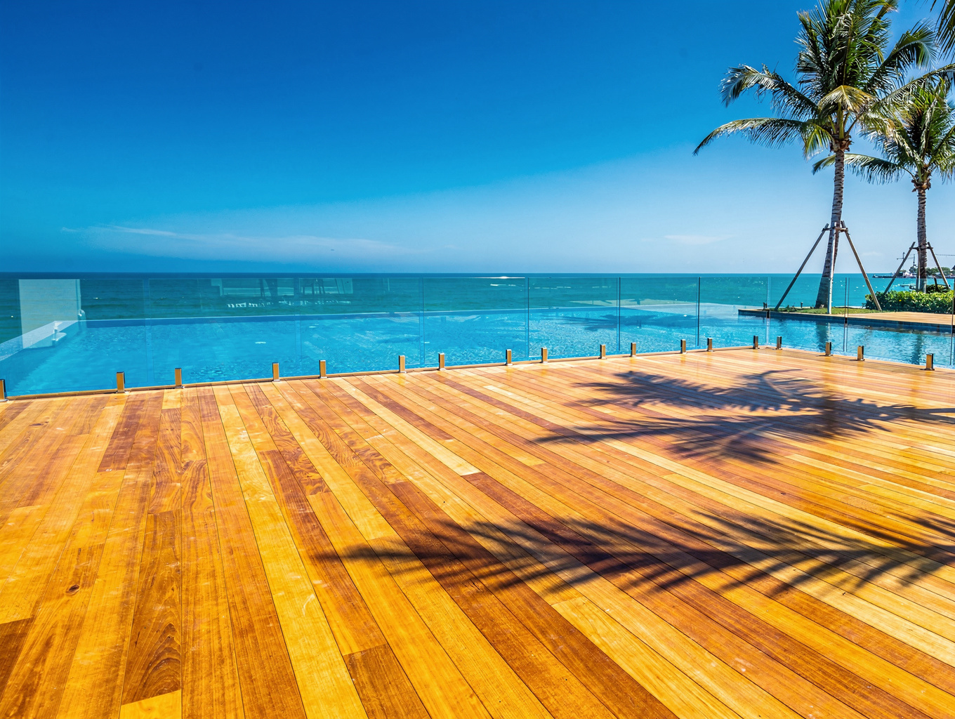 Flush poolside hardwood boardwalk with concealed perimeter drainage